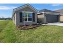 Front yard with lush grass and a flower bed featuring a small tree at 13290 Ogden Glade Rd, Dade City, FL 33525
