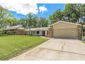 Single-story home featuring a two-car garage and extended driveway on a sunny day at 823 Scenic Heights Dr, Brandon, FL 33511