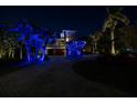 Elegant two-story home beautifully lit at night with palm trees and a brick driveway at 8755 Commodore Dr, Seminole, FL 33776
