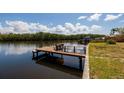 Waterfront home featuring a wood dock perfect for boating and fishing, nestled amidst lush greenery at 9439 Sun Isle Ne Dr, St Petersburg, FL 33702