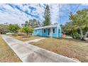 Charming light blue home featuring a well-maintained lawn and inviting curb appeal in a desirable neighborhood at 1841 Overbrook Ave, Clearwater, FL 33755