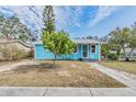 Beautifully renovated light blue home with white trim, lush landscaping, and inviting entrance at 1841 Overbrook Ave, Clearwater, FL 33755