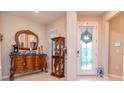 Elegant foyer with decorative mirror, display cabinet, and a patterned glass front door at 19367 Coastal Shore Ter, Land O Lakes, FL 34638