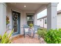 Inviting front porch with rocking chairs, potted plants, and a welcome mat at 19367 Coastal Shore Ter, Land O Lakes, FL 34638