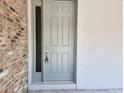 A gray front door featuring a brick exterior and glass pane welcomes you home at 422 Shannon Estates Ct, Plant City, FL 33563