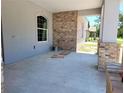 Open-air patio featuring brick columns, gray stucco, and a welcoming arched window, perfect for relaxing outdoors at 422 Shannon Estates Ct, Plant City, FL 33563