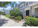 Well-manicured front exterior of a lovely townhome with lush landscaping, walkway, and welcoming black front door at 8856 Christie Dr # 0, Largo, FL 33771