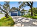 Charming single-story home featuring a blue exterior, well-maintained lawn, and an attached garage at 3009 E 148Th Ave # B, Lutz, FL 33559