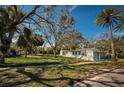 Well-maintained home on a spacious lot with mature trees and lush green grass at 402 Pineapple St, Tarpon Springs, FL 34689