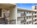 Condo exterior with stairs and balconies, featuring stucco facade, and metal railings at 225 Country Club Dr # 1611, Largo, FL 33771
