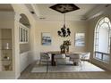 Elegant dining room featuring a tray ceiling, modern chandelier, and stylish decor elements at 2850 Deer Run, Tarpon Springs, FL 34688