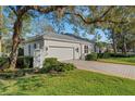 Beautifully landscaped exterior with a paved driveway and mature trees giving the home great curb appeal at 2850 Deer Run, Tarpon Springs, FL 34688