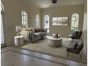 Cozy living room with neutral tones, large windows, and comfortable seating arrangement at 2850 Deer Run, Tarpon Springs, FL 34688