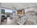 Bright, open-concept living room and kitchen with city view, updated cabinets, tile floors and stainless appliances at 31 Island Way # 303, Clearwater Beach, FL 33767
