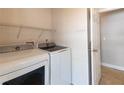 Practical laundry room featuring a modern washer, dryer, and storage shelves for added convenience at 5142 Serene Sq, New Port Richey, FL 34653