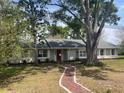 Charming single-story home boasts a red brick walkway, mature trees, and a freshly painted exterior at 1758 Winfield Cir, Clearwater, FL 33756