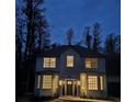 Charming two-story home with a well-lit exterior, dark shutters, and a welcoming front entrance at twilight at 19018 Geraci Rd, Lutz, FL 33548