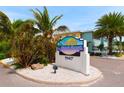 Barefoot Beach Resort sign with palm trees, landscaped island, and well-maintained grounds at 19417 Gulf Blvd # C210, Indian Shores, FL 33785