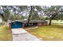 Charming single-story home with brick and siding, a long driveway, and mature trees at 36441 Lake Pasadena Rd, Dade City, FL 33525
