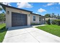 View of the property showcasing the driveway leading up to the home's garage and freshly cut lawn at 10019 N Hyaleah, Tampa, FL 33617