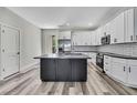 Modern kitchen featuring white cabinets, stainless steel appliances, subway tile backsplash, and a gray island at 10019 N Hyaleah, Tampa, FL 33617