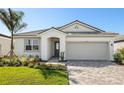 Single-story home featuring a neutral color scheme, well-manicured lawn, and a two-car garage at 12193 Meditation Trl, Venice, FL 34293