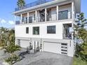 Stunning exterior of home featuring a multi-level design with a rooftop patio and spacious garages at 18077 3Rd St, Redington Shores, FL 33708