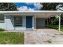 Inviting single-story home with a covered entrance and carport, set against a lush green backdrop at 8902 Temple Park Dr, Tampa, FL 33637