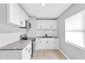 Bright kitchen with white cabinets, granite countertops, stainless appliances, and neutral tile flooring at 8902 Temple Park Dr, Tampa, FL 33637