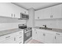 Stylish kitchen features white cabinets, stainless steel appliances, and granite countertops at 8902 Temple Park Dr, Tampa, FL 33637