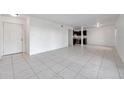 Bright living room features white tiled floor and an open floor plan with a view of the modern kitchen at 107 Seahorse Se Dr # A, St Petersburg, FL 33705