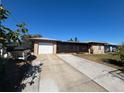 Charming single-story home with a long driveway, attached garage and screened front porch at 27064 Omni Ln, Punta Gorda, FL 33983