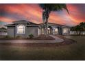 Beautiful home at sunset, featuring manicured landscaping and a welcoming entrance at 9413 Swift Creek Cir, Dover, FL 33527