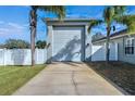 A well-maintained garage on a sunny day with a long driveway and palm trees at 9413 Swift Creek Cir, Dover, FL 33527