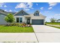 Beautiful home exterior featuring manicured lawn, landscaped garden, and a spacious concrete driveway at 5283 Everlong Dr, Apollo Beach, FL 33572