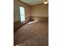 A bedroom with paneled walls, carpeted floor, and window at 1463 Bobolink St, Zephyrhills, FL 33540