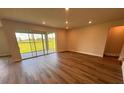Living room featuring plank floors, neutral paint, recessed lighting, and sliding doors to the backyard at 4319 Pullet Ct, Bradenton, FL 34211