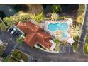 Aerial view featuring a pool with cabana, palm trees, lounge seating, and parking at 12077 Gandy N Blvd # 344, St Petersburg, FL 33702
