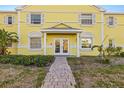 Charming entryway with double doors and a brick path, set in a building with vibrant yellow siding at 3889 Pompano Se Dr # A, St Petersburg, FL 33705