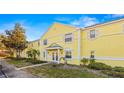 Bright yellow condominium with a manicured lawn and lush landscaping, under a blue sky at 3889 Pompano Se Dr # A, St Petersburg, FL 33705
