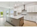 Modern kitchen features a large center island, stainless steel appliances, and wood flooring at 5289 Everlong Dr, Apollo Beach, FL 33572