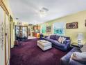 Open-concept living room shows the purple sofa, a decorative screen, with views into the kitchen at 5309 21St S Ave, Gulfport, FL 33707