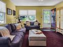 Inviting living room features a comfortable purple sofa, an ottoman, and natural light from a window at 5309 21St S Ave, Gulfport, FL 33707