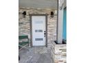 Stylish front door with modern accents and unique stone trim for enhanced curb appeal at 16108 5Th E St, Redington Beach, FL 33708