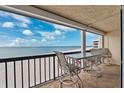 Relax on the spacious balcony overlooking the beach, complete with tile flooring and patio furniture at 19450 Gulf Blvd # 401, Indian Shores, FL 33785