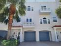 Charming three-story townhome with a private garage, balconies, and tropical landscaping at 145 Brightwater Dr # 2, Clearwater, FL 33767