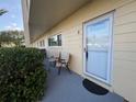 Cozy front porch area with seating and a secure front door with glass panes for natural light at 2258 World Parkway W Blvd # 8, Clearwater, FL 33763