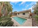 Backyard pool with patio and lush landscaping, creating a serene and private oasis for relaxation at 435 Meadowlark Ln, Palm Harbor, FL 34683