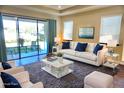 Bright living room with modern decor, plush rug, and sliding glass doors to the outdoor space at 5426 Rushmere Ct, Palmetto, FL 34221