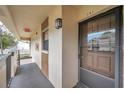 Exterior view of unit 201 featuring a secure front entry door, and private covered porch at 2700 Nebraska Ave # 3-201, Palm Harbor, FL 34684